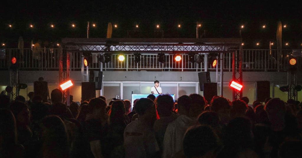 Silhouettes of the crowd facing the stage